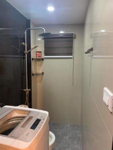 La salle de bains est pourvue de toilettes et d'une porte de douche en verre. dans l'établissement Clark pampanga( dale’s crib), à Mabalacat