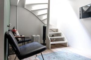 a living room with a chair and a staircase at 1001 Nights Boutique Lofts in Haarlem