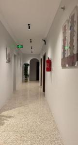 a hallway with white walls and paintings on the walls at غيوم in Mecca