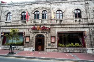 a large stone building with windows and a store at Roka Plaza Hotel Boutique in Ambato