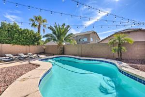 a swimming pool in a backyard with a fence and palm trees at Avondale Home with Pool, 5 Mi to State Farm Stadium! in Avondale