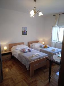 1 dormitorio con 2 camas y lámpara de araña en Apartment Meri, en Trogir