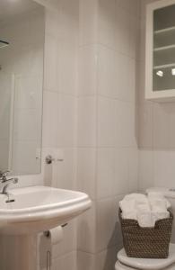 a white bathroom with a sink and a toilet at La casina de cori in Luarca