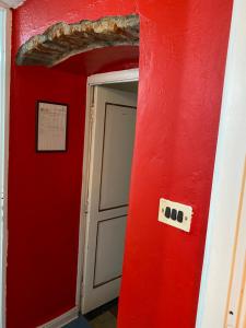 Habitación roja con puerta y pared roja en Red appartament, en Bagnolo Piemonte