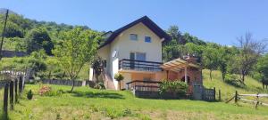 ein Haus am Hang mit einem Zaun in der Unterkunft Vikendica Jovanovic in Foča