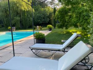 a white swinging chair next to a swimming pool at Villa de Miha in Valbonne