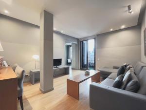 a living room with a couch and a table and a television at Stay U-nique Apartments Rambla Catalunya II in Barcelona