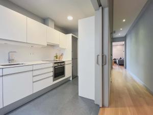 a kitchen with white cabinets and a hallway at Stay U-nique Apartments Rambla Catalunya II in Barcelona