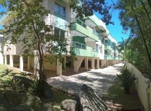 un edificio con balcones y árboles en una calle en Apto com 02 quartos Praia da Conceição Bombinhas SC, en Bombinhas