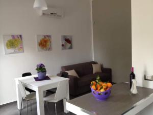 un soggiorno con divano e tavolo con cesto di frutta di Chianurrè Arancio a Partinico