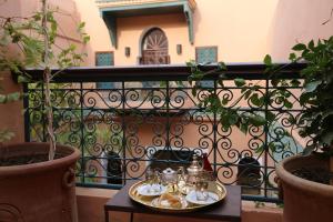 a tray of tea sets on a table on a balcony at Palais Riad Lamrani in Marrakesh