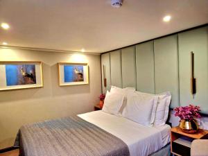 1 dormitorio con 1 cama grande con almohadas blancas en Costa do Sal Hotel Boat Lounge, en Aveiro