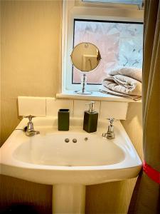 a bathroom with a sink and a mirror and towels at Double room bentilee in Bucknall
