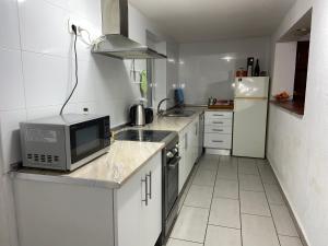 a small kitchen with a microwave and a refrigerator at Les Oliveres - casa- apartament in Vilafant