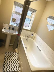 a bathroom with a bath tub and a sink at Double room bentilee in Bucknall