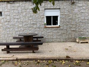 a picnic table next to a brick wall with a window at Les Oliveres - casa- apartament in Vilafant