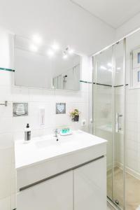 a white bathroom with a sink and a shower at Nice Apartment with Veranda in Gaia - 3D in Vila Nova de Gaia