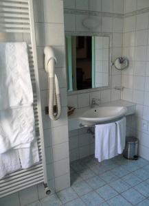 Deco Hotel في بيروجيا: حمام أبيض مع حوض ومرآة