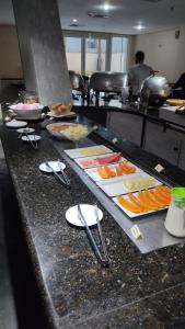 uma linha de buffet com pratos de comida e utensílios em Transamerica Executive Perdizes em São Paulo