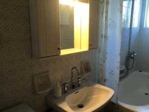 ein Badezimmer mit einem Waschbecken, einem Spiegel und einer Badewanne in der Unterkunft MARIAS APARTMENT SMART KEY BOX by PROJECT 86 IKE in Agrinio
