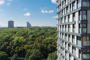 a tall building with trees in the background at Residence Garden Tower - zimni zahrada in Prague