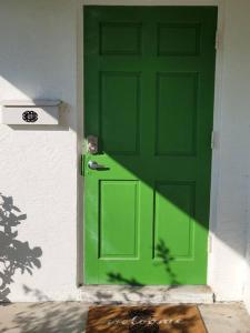 een groene deur aan de zijkant van een huis bij Beachy Sarasota Duplex in Sarasota