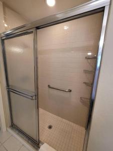 een douche met een glazen deur in de badkamer bij Beachy Sarasota Duplex in Sarasota