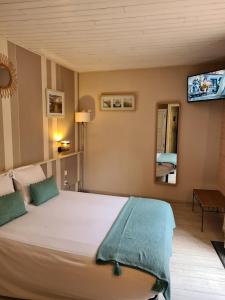 1 dormitorio con 1 cama grande y TV en la pared en Le Royal Hôtel, en Saint-Pol-sur-Ternoise