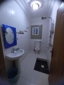 a white bathroom with a sink and a toilet at The Rock Garden Apartments in Amdalai