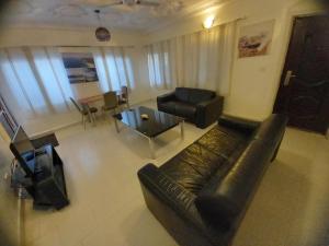 a living room with a leather couch and a table at The Rock Garden Apartments in Amdalai +9 photos
