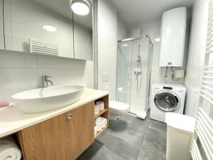 y baño con lavabo y lavadora. en Lux Apartment Ski&Golf en Kranjska Gora