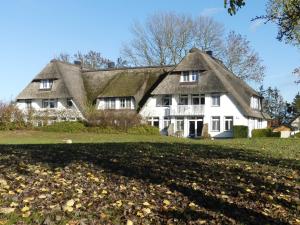 a white house with a thatched roof at Landhaus am Haff in Stolpe auf Usedom