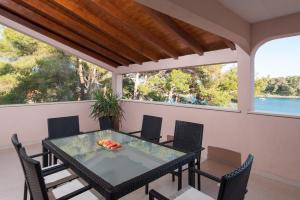 Una mesa y sillas en un balcón con vista al agua. en Apartment Prižba - Korčula, en Prizba