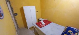 Mały pokój z łóżkiem z czerwoną poduszką w obiekcie Otasho Nile view house w mieście Aswan