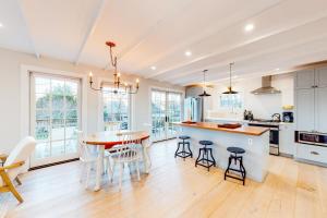 cocina y comedor con mesa y sillas en Modern Harbor Retreat en Rockland