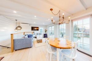a dining room with a table and a couch at Modern Harbor Retreat in Rockland