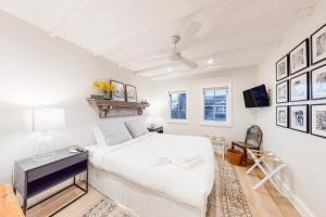 a white bedroom with a bed and a tv at Modern Harbor Retreat in Rockland