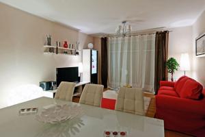 a living room with a table and a red couch at Glamour Apartments Sopot in Sopot