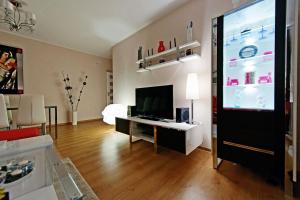 a living room with a flat screen tv and a living room with a room at Glamour Apartments Sopot in Sopot