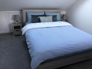 a large bed in a bedroom with two lamps at Ainslie Loft in Chingford, London in Chingford
