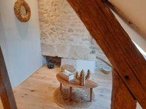 a room with a table and a stone fireplace at Chez collette in Chablis