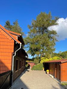 ein Haus mit einem orangenen Dach und einer Auffahrt in der Unterkunft Ferienwohnungen Marianne Lau in Wernigerode
