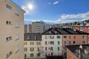 a view of a city with buildings and the sun at Modern BOHO STYLE SUITE in Lugano City -By EasyLife Swiss in Lugano