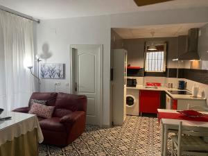 a living room with a couch and a kitchen at Casa rural Hnas Corral in Almoharín
