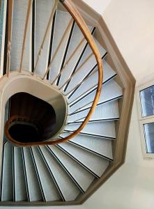 a spiral staircase in a room with a window at Hotel Victoria in Strasbourg