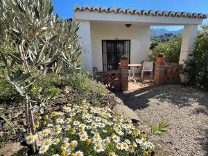 a small house with a table and some flowers at Casa del Limon in Canillas de Aceituno