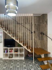 a living room with a staircase and a tv at Casa rural Hnas Corral in Almoharín +12 photos