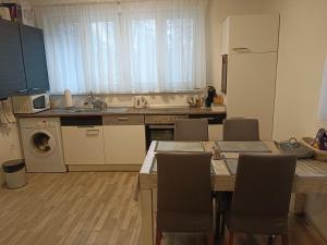 Šaštín的住宿－Apartmán Kocka，厨房配有水槽和桌椅