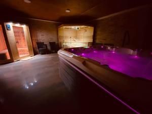 a large bathroom with a tub with purple lighting at Gold Horse Vendégház in Szilvásvárad