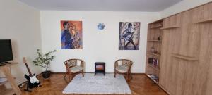- un salon avec deux chaises et une cheminée dans l'établissement Happy Mood Apartment 5, à Braşov